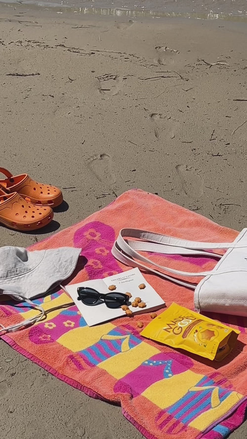 Video at the beach a blanket, beach accessories and a pouch of star crackers